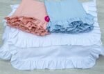 baby blue cotton pillowcases adorned with ruffles all around them