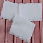 white muslin squares adorned with hand made lace trims and hand embroidered