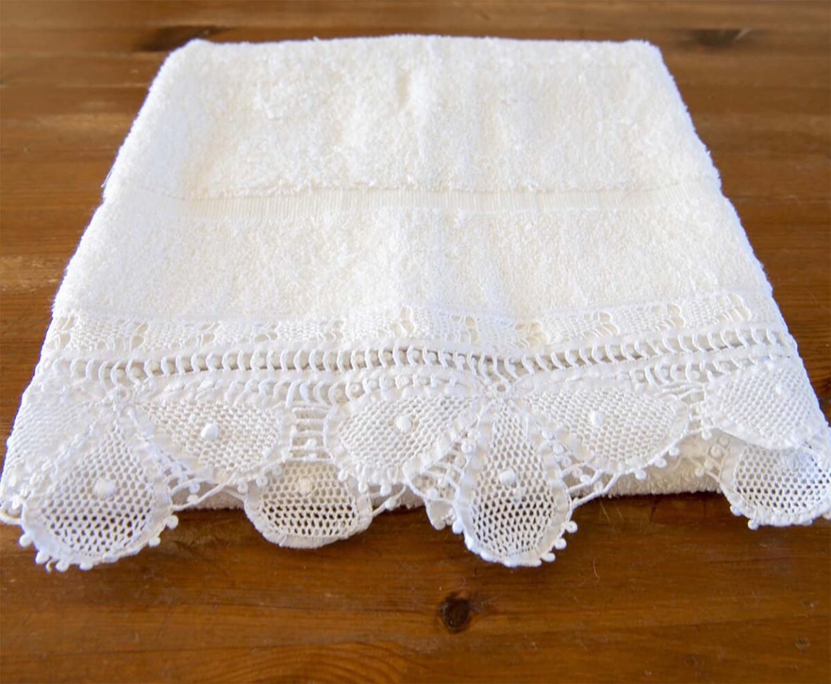 White bath towels fluffy adorned with a wide strip of handmade lace trim